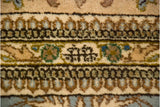 A close-up of the weaver's insignia woven in chocolate brown on a vintage Tabriz carpet.