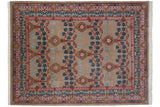 Vintage Indian Arts and Crafts carpet with a blue and pink floral trellis design on a warm, sandy beige field.