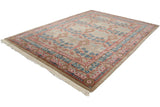 Angled view of a vintage Indian carpet highlighting the carved texture of its sprawling floral design.