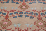 Carved Arts and Crafts rug detail with terracotta branches, blue leaves, and pink floral medallions.