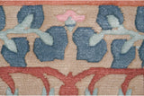 Carved texture outlines the blue, pink, and terracotta floral motifs on the wool pile.