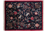 Vintage Indian carpet with carved cloudband ribbons and knots on a deep navy blue field.
