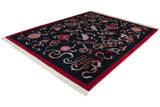 Oblique view of a vintage Indian Peking carpet with a navy field, red border, and sprawling cloudband motifs.