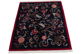 Angled view of a vintage Indian Peking carpet showing the full sprawling design and red border.