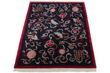Vintage Indian carpet viewed at an angle, showing carved motifs and a red border.