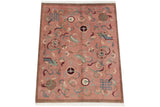 Vintage Indian Peking carpet corner, dusty blush field, endless knot motifs, shallow carved contour, fringe.
