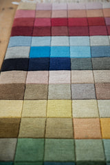 Modern design rug with shallow carved rainbow squares and transitioning colors.