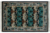 Sprawling Arts and Crafts floral and vine motifs in teal and silver on a vintage Indian carpet.