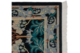 Corner of an Arts and Crafts rug showing the teal floral border, plush pile, and white fringe.