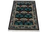 Angled view of a vintage William Morris carpet showing the full floral and tree design.