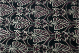 Shallow carved contour defines the burgundy and platinum floral motifs on a black field.