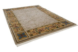 Angled view of vintage Indian Savonnerie carpet, beige carved floral field, colorful ornate border.