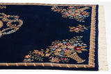 Corner of vintage Aubusson design carpet with floral vase motif, corded border, and plush pile.