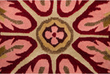 Shallow carved contours of the floral medallion in cherry red and rose pile.