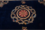 Detail of the shallow carved floral medallion against the rich cobalt blue pile.
