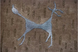 Carved slate blue antelope on a textured coffee brown and dark olive pile.