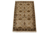 Indian William Morris carpet corner: beige field, brown palmettes, sage vinery, ivory fringe.