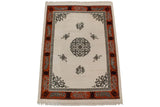 Vintage Indian Peking rug corner detail, with tangerine border, grey Greek key, and floral spandrel.