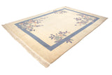 Art Deco rug corner with carved floral bouquet in pale blue, mauve, and jade.