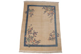 Carved mauve, dusty rose, and jade florals on Art Deco rug corner with blue border.