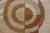 Textured hand-woven Soumac carpet showing abstract circles and blocks in ivory, beige, copper tones.