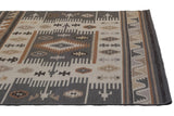 Corner of Indian Soumac rug, geometric design with serrated contours in ivory and charcoal.