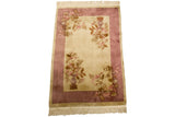 Vintage Art Deco rug with carved floral design, mirrored vases, ivory field, mauve border.