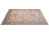Indian Sultanabad carpet shown at an angle, detailing its floral medallion and dusty slate blue border.