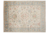 A detailed view of the Sultanabad carpet's floral medallion and vines in blush, terracotta, and dusty blue.