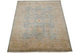 Wheat and beige border with palmettes and blossoms, adjoining dusty blue field and fringe.