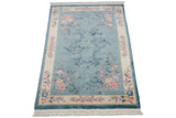 Fringed bottom corner of sky blue Art Deco carpet, carved ivory floral border.