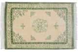 Ivory and moss green Vintage Indian Peking rug with roundel medallion and stylized bat motifs.