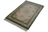 Vintage Indian Peking rug's moss green border, butterfly and pearl motifs, ivory field, fringe.