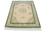 Vintage Indian Peking rug corner, showing cream fringe and moss green pearl and butterfly-like borders.