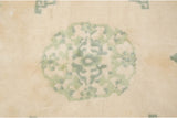 Textured moss green roundel design on the ivory field of a vintage Peking rug.