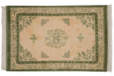 Vintage Indian Peking design rug corner with moss green border, pearl design, and fringe.