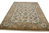 Rococo scrolling leaves, vines, and blush, sky blue floral motifs on Savonnerie rug.