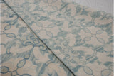 Three-dimensional reverse Soumac weave texture with ivory and powder blue floral design.