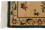 Hand-knotted vintage Peking rug corner showing ivory fringe, green border, and raspberry red flower.