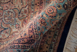 Close-up of rolled Indian Ardebil rug displaying intricate blush, sky blue floral pile.