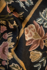 Close-up of the textured chainstitch weave showing floral bouquets in rose and gold.