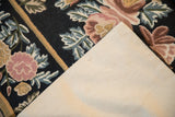 View of the cotton backing and textured floral chainstitch front of the vintage rug.
