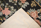 Vintage chainstitch rug's woven backing contrasts dusty rose and blue floral motifs.