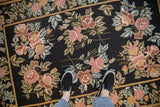 A view from above showing the textured floral chainstitch on a black vintage area rug.
