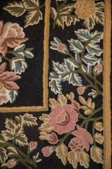 Textured chainstitch weave of rose, blue, and olive floral bouquets on a black field.