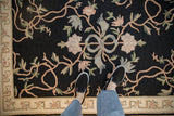 Overhead view showing the texture and floral ribbon design of a vintage chainstitch rug.