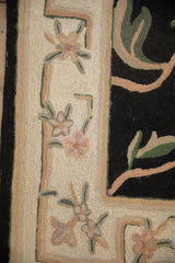 Intricate chainstitch weave showing floral border motifs in dusty rose and ivory.