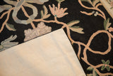 Clean ivory fabric backing and floral chainstitch details of a vintage Indian rug.