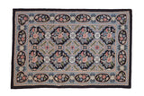 Vintage chainstitch rug with floral bouquets on a black field and a dusty blue border with oval panels.