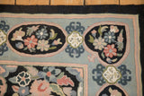 Chainstitch texture on floral panels in pale rose and dusty blue on a vintage rug.